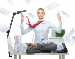Calm business woman despite huge disorder on table and flying papers